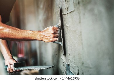 closeup hand of worker plastering cement at wall for building house                                