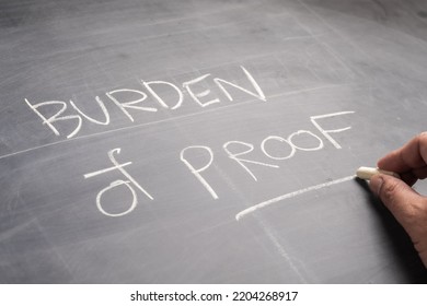 Closeup hand write the text Burden of Proof, on the blackboard, topic of law learning concept