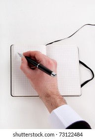Close-up of hand writing in notebook