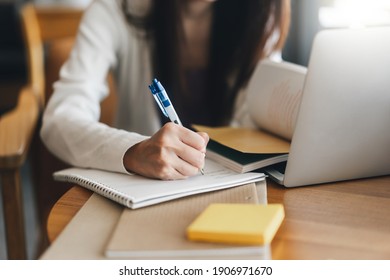 Closeup Hand Young Adult Women Writing Note For Study And Work Online. Workplace Table With Laptop Computer And Mobile Phone. University People City Lifestyle At Outside From Home On Day Concept.