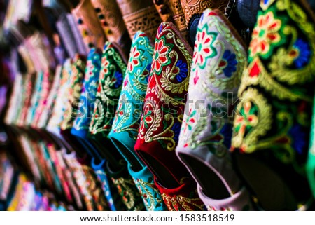 Close-up of handmade colorful embroidered cloth slippers (babouches) for sale in an artisan market in Morocco. Traditional moroccan shoes. Oriental style concept.