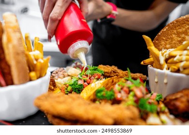 Close-up of hands adding sauce to fast food items like fries and burgers. Vibrant colors and a blurred background emphasize the action and food. Ideal for culinary, fast food, and lifestyle themes. - Powered by Shutterstock