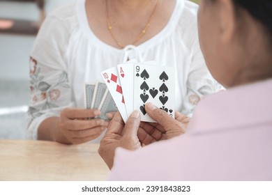 Closeup hands of asian elderly person spending free times with friends by playing cards at home after retirement happily, new edited. - Powered by Shutterstock