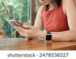 Closeup hands of asian woman using smartphone to social media online sitting on chair in living room at cafe, Young woman looking smart phone chat message