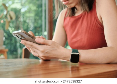 Closeup hands of asian woman using smartphone to social media online sitting on chair in living room at cafe, Young woman looking smart phone chat message - Powered by Shutterstock