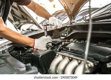 Close-up hands of auto mechanic are using the wrench to repair and maintenance auto engine is problems at car repair shop. Concepts of car care check and fixed and services insurance. - Shutterstock ID 1905873049