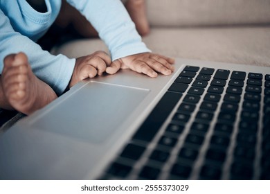 Closeup, hands and baby with laptop in home, playing and online for streaming entertainment. Child, infant feet and relax on couch for cartoon movies, living room and wireless internet for film - Powered by Shutterstock