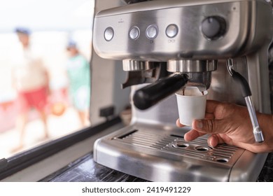 Close-up of hands of a barista preparing espresso coffee in a food truck - Powered by Shutterstock