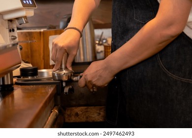 Close-up hands of barista steaming milk with espresso machine in modern cafe. Male hand holding stainless steel pitcher under steam wand. Professional barista equipment visible. Coffee preparation. - Powered by Shutterstock