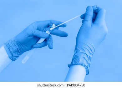 Close-up of hands in blue protective gloves holding a test tube of coronavirus swab collection kit for taking OP NP patient sample sample, PCR DNA testing protocol process. PCR test. Toned - Powered by Shutterstock