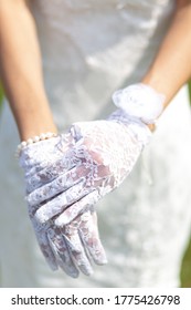 Close-up Hands Of The Bride In White Lace Gloves. Selective Focus