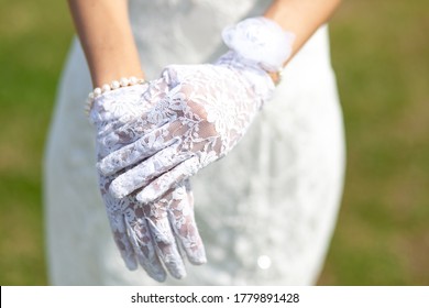 Close-up Hands Of The Bride In White Lace Gloves. Selective Focus