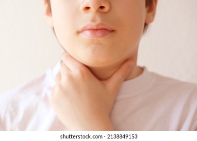 close-up of hands of child holds throat, boy of 10 years old is sick, concept of children's health, pediatrics, thyroid inflammation, Overview of the Thyroid Gland, loss of voice