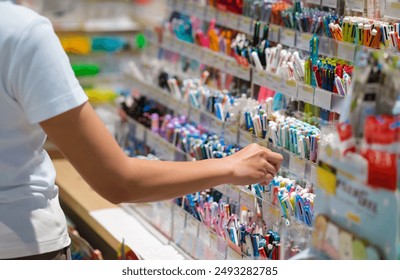 Close-up hands choosing school stationery in the supermarket. - Powered by Shutterstock