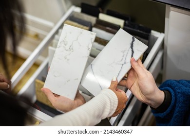 Closeup Hands Creative Female Interior Designer And Customer Choosing Marble Stone Color For Kitchen Or Facades. Top View Woman Client Consulting To Decorator Choice Home Improvement Materials