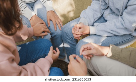 Close-up hands of diverse multiracial male and female group sit circle explain tell story sharing together in park. Support and understand at psychological therapy session, PTSD Mental health concept. - Powered by Shutterstock