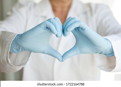 Close-up Of The Hands Of A Doctor Or Nurse Wearing Latex Gloves And Creating A Heart With Them