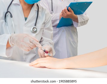 Closeup Hands Of Doctor Use Syringe On Patient’s Hands Do Blood Test With Trainee Standing Beside And Taking Note. White Copy-space, Healthcare Medical Care Concept