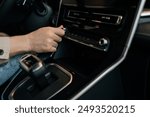 Closeup hands of driver male adjusting temperature in car by rotate. Close-up of man hand hold button of temperature. Close up of human hand rotating car temperature control.