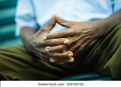 closeup of hands of elderly african american man sitting on bench