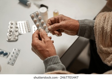 Close-up of the hands of an elderly man holding pills and medicines in his hands. Medicine and treatment concept. copy space - Powered by Shutterstock