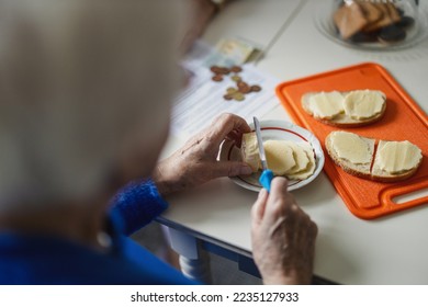 Close-up of the hands of an elderly woman making sandwiches - Powered by Shutterstock