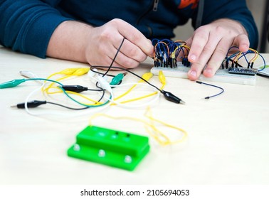Close-up hands with electronics development board. Robot microcontrollers board and equipment in robotics laboratory school.