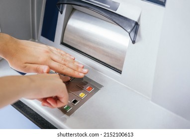 Close-up Of Hands Entering And Hiding PIN Number Password Code On ATM Bank Machine Key Pad. Secure Banking Operations And Habits Against Theft Through Card Cloning