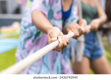 Close-up of hands gripping a rope in a tug-of-war competition, focus on teamwork and effort. Participants wear casual clothing, highlighting a fun and competitive outdoor activity. - Powered by Shutterstock