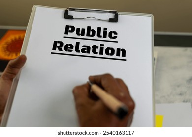 Close-up of hands holding clipboard with "Public Relation" written, emphasizing communication and image management. - Powered by Shutterstock