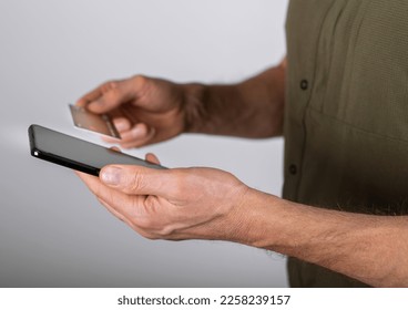 Closeup hands holding credit bank card and smartphone, paying online, using financial mobile phone application, shopping in internet. High quality photo - Shutterstock ID 2258239157