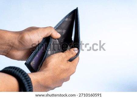 Close-up of hands holding an open empty wallet, symbolizing financial hardship, budgeting issues, poverty, or economic struggle. Ideal for finance-related themes.