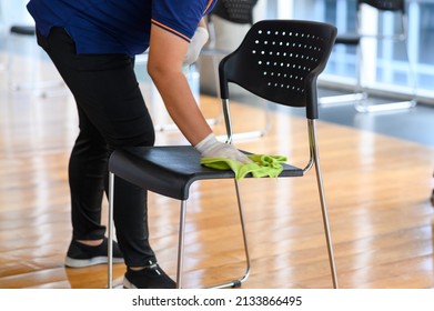 Close-up Hands Of Housekeeper Cleaning Chair In Meeting Room Prevention Of Corona Virus 2019 Or Covid 19 Infection, Protection Against The Corona Virus. Save And Clean In Public Building