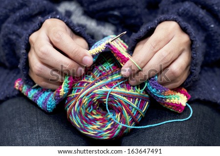 Close-up of hands knitting colorful wool