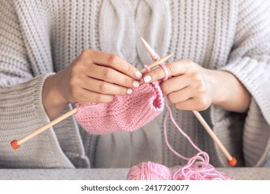 Close-up of hands knitting using circular needles.