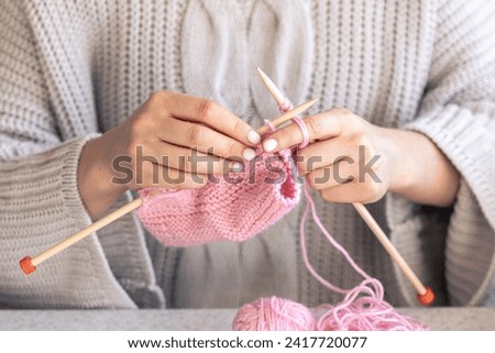 Close-up of hands knitting using circular needles.