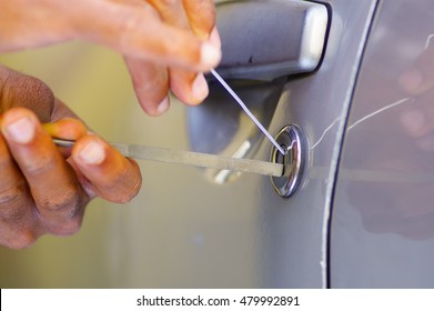 Closeup Hands Of Locksmith Using Pick Tools To Open Locked Car Door