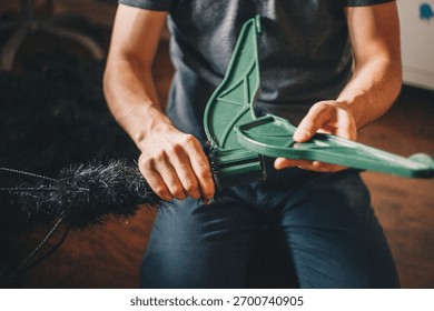 Closeup of hands of a man assembling a Christmas tree