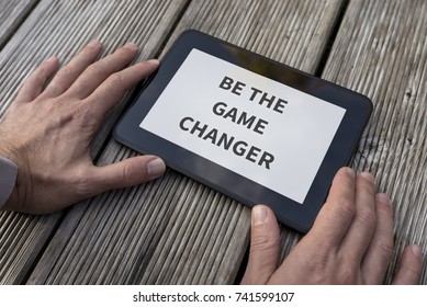 Close-up Of The Hands Of A Man Holding A PC Tablet With A Motivational And Inspirational Message Be The Game Changer.