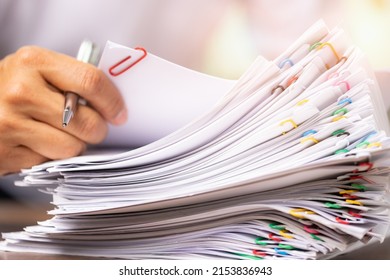 Close-up Hands Of A Man In A White Shirt Searching For Contract Agreement Documents In Stack Of Group Report Papers Clipped In Color Clips In Fair Light, Business, Legal Law And Education Concept.