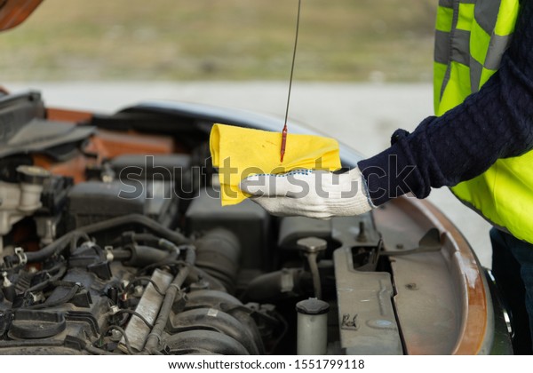 Close-up of the hands of a\
mechanic doing a car service on the road. The concept of roadside\
assistance
