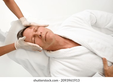 Close-up Of Hands In Medical Gloves Of Aesthetician Performing Facial Lifting Smoothing Anti-aging Professional Massage Of Mature Man's Face. Skin Care, Male Beauty Procedures Concept At Wellness Spa