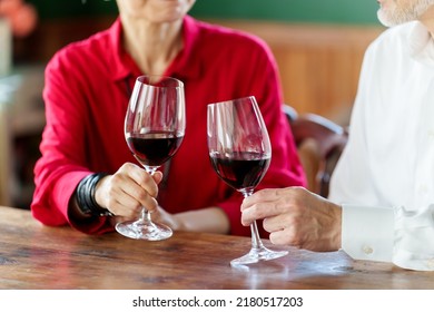 Closeup Hands Of Middle Aged Asian Couple Toasting With Red Wine