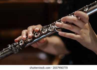 A closeup of hands of a musician playing the flute - Shutterstock ID 2037900770