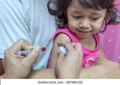 Close-up hands, nurses are vaccinations to children using the syringe. Doctor vaccinating women in hospital. Are treated by the use of sterile injectable upper arm. injection