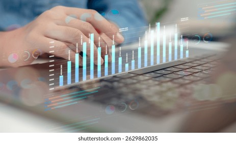 Close-up of hands on laptop keyboard with digital analytics dashboard, bar chart, and data visualization, representing financial analysis, business intelligence, and KPI tracking.