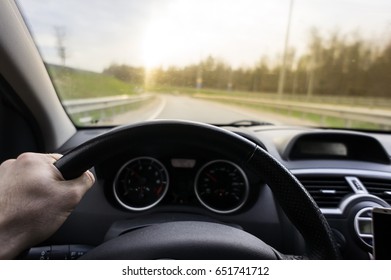 Close-up of hands on a steering wheel.