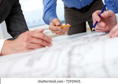 Close-up of hands with pencils over a draft - Powered by Shutterstock