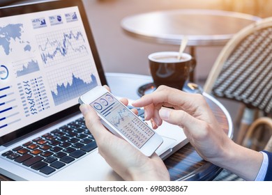 Close-up of hands of person analyzing stock market chart and key performance indicators (KPI) with business intelligence (BI) on notebook computer and smartphone screen, fintech (financial technology) - Powered by Shutterstock
