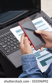 closeup of hands with the phone mobile, the computer laptop and those documents